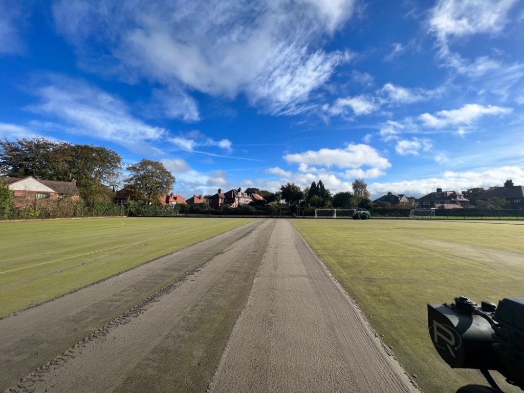 During replays rejuvenation on a sand filled pitch removing dirt and algae