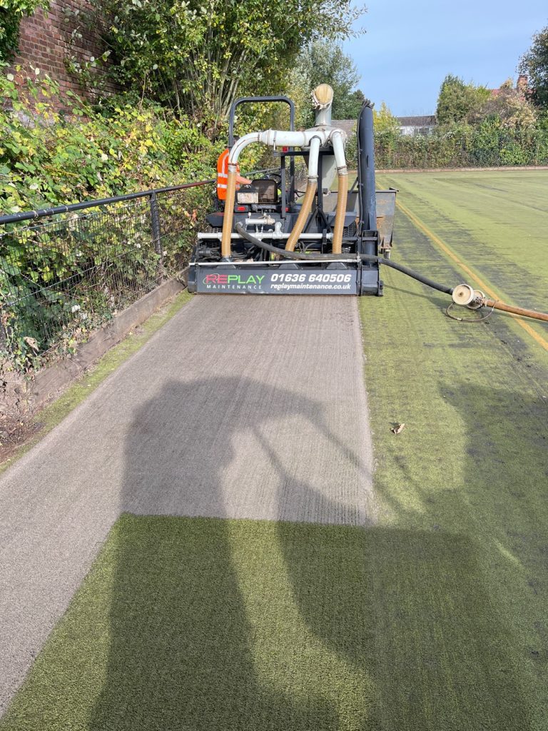 Rejuvenation machinery on sand filled court working on deep cleanign sand filled pitch 