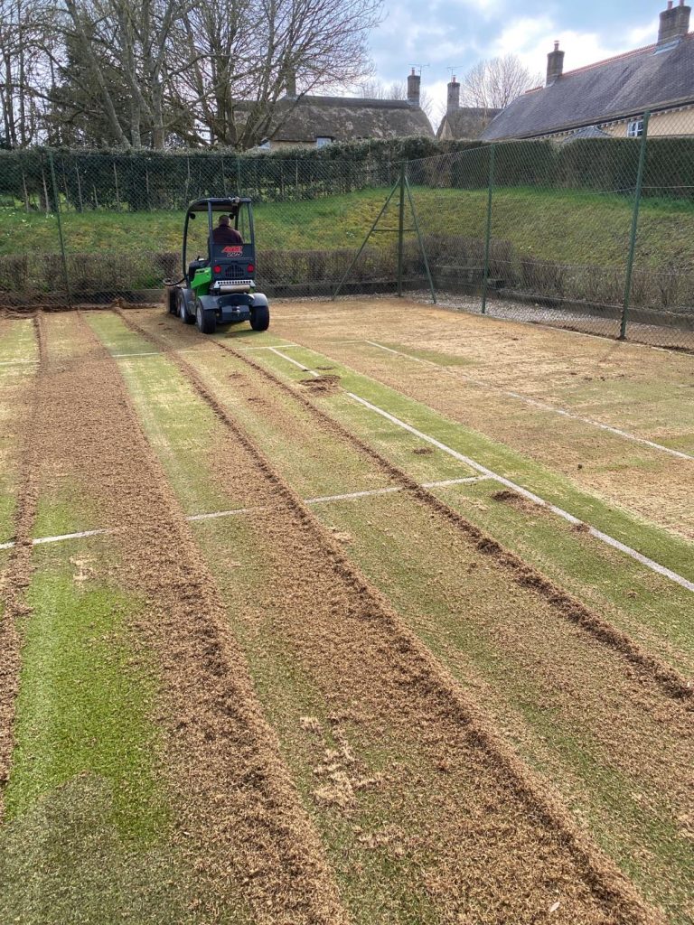 Machinery working on tennis court to pull out any contamination and infill to restore the surface